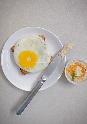 A picture of Olive oil fried egg and hummus toast.