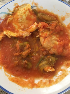 Una foto de Torta de huevo en salsa de tomate y flor de calabaza