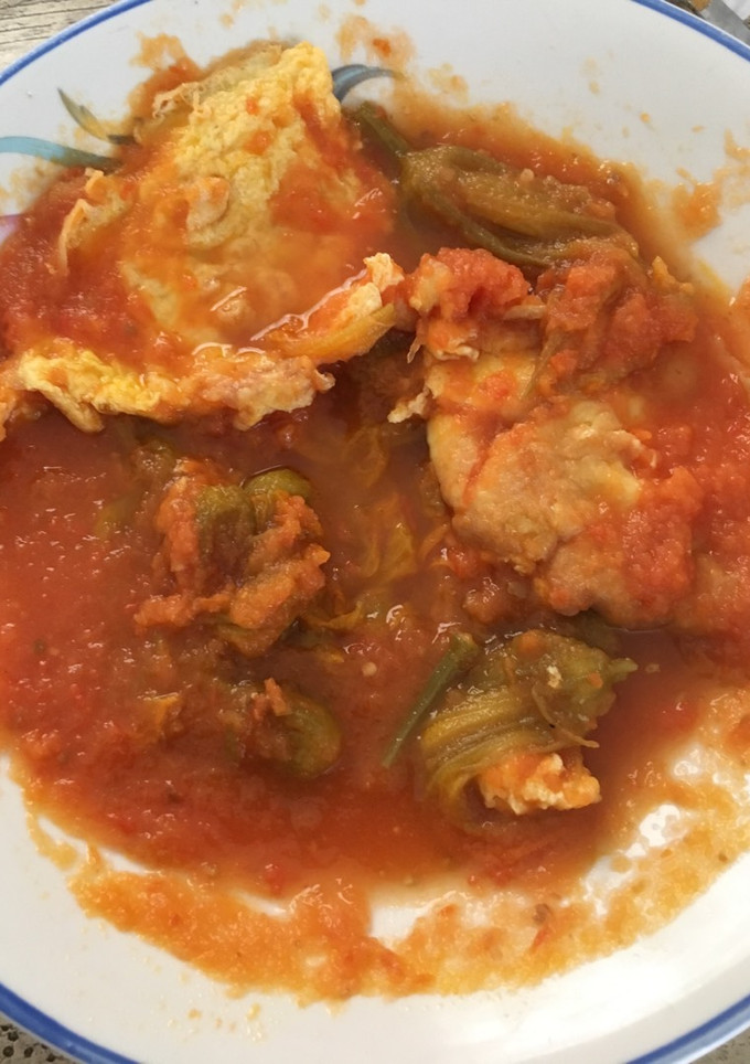Una foto de Torta de huevo en salsa de tomate y flor de calabaza