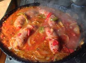 Una foto de Chorizos a la pomarola fácil y ricos con puré de papas