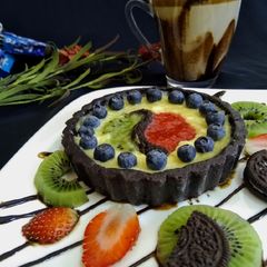 A picture of Oreo chocolate tart with fruit puree.