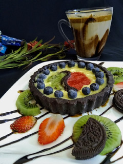 A picture of Oreo chocolate tart with fruit puree.