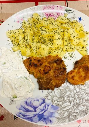 O poză a rețetei Cartofi natur cu marar deasupra și șnițele din carne de porc la cuptor cu sos tzatziki.