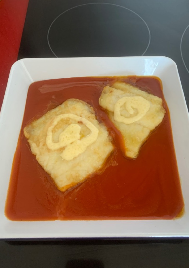 Una foto de Bacalao en cama de tomate con alioli