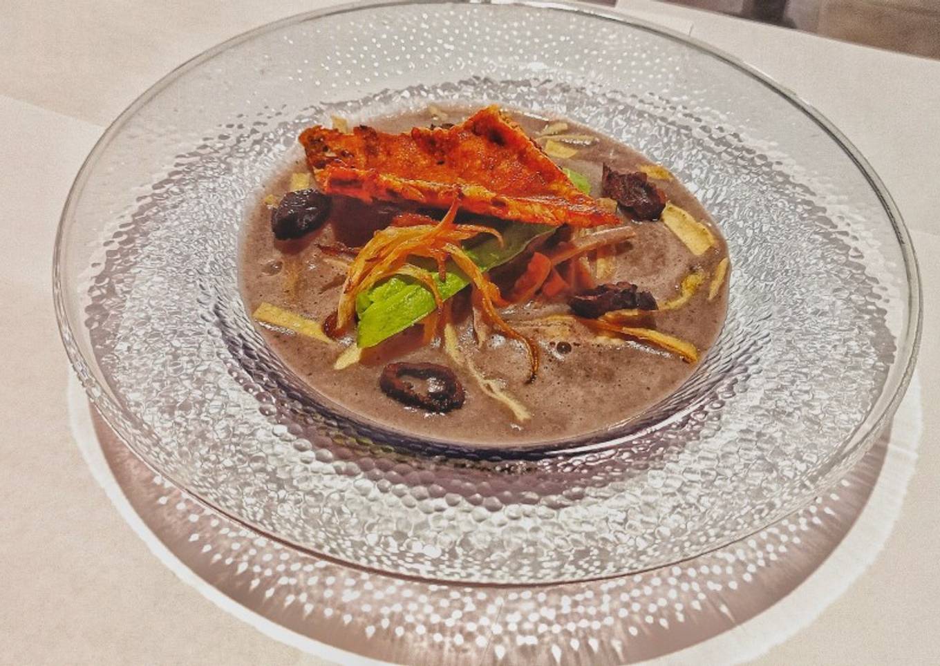 Crema de frijol y costra de quesillo con chapulines