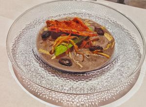 Una foto de Crema de frijol y costra de quesillo con chapulines