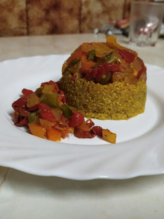 Una foto de Quinoa especiada con pimientos y cebolla