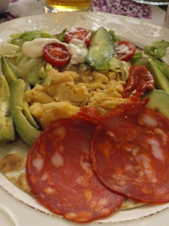 Una foto de Tortilla con perejil rellena con huevos revueltos, salchichón y jamón