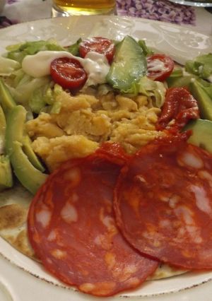 Foto principal de Tortilla con perejil rellena con huevos revueltos, salchichón y jamón