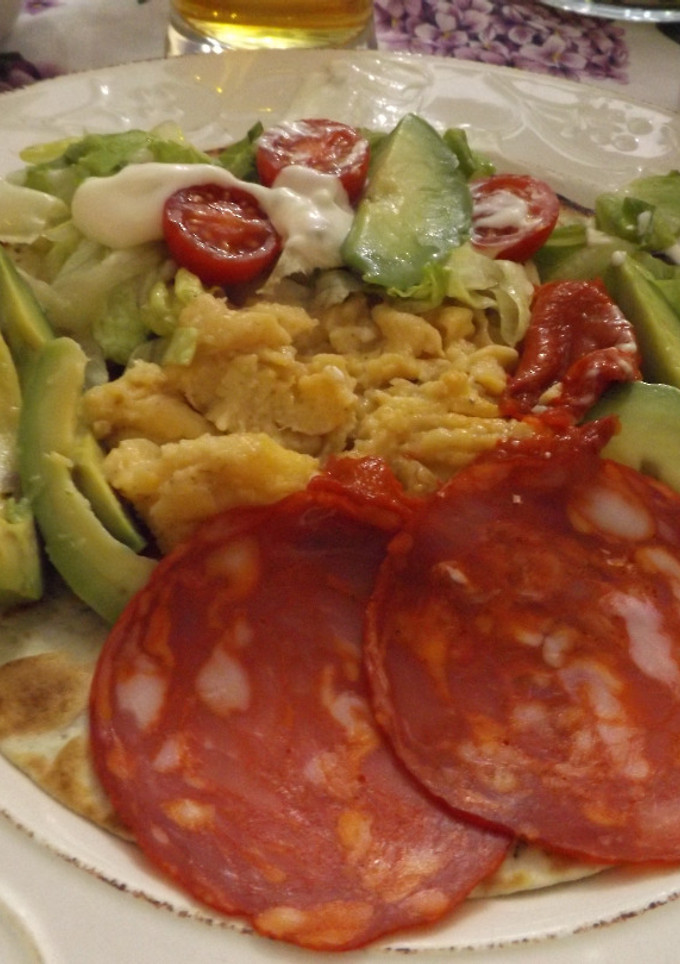 Una foto de Tortilla con perejil rellena con huevos revueltos, salchichón y jamón