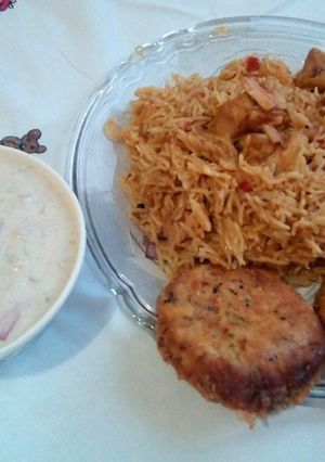 A picture of Achari Chicken Rice with Raita.