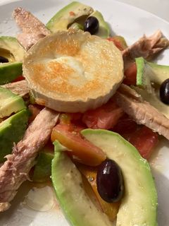 Una foto de Ensalada de melva, aguacate, tomate, con queso de cabra tostado