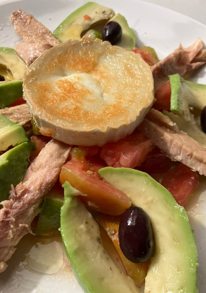 Una foto de Ensalada de melva, aguacate, tomate, con queso de cabra tostado