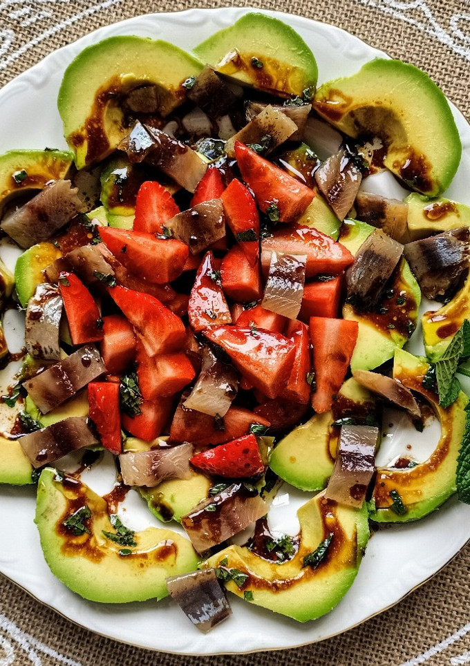 Una foto de Ensalada de aguacate, anchoas naturales, fresas y hierbabuena
