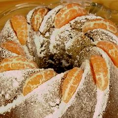 A picture of Tangerine cake with hazelnuts and chocolate chunks.