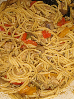A picture of Chinese noodles with chicken and veggies.