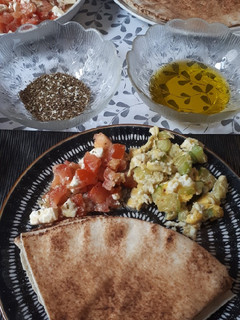 Una foto de Brunch de ensalada de tomate y queso y revuelto de calabacín