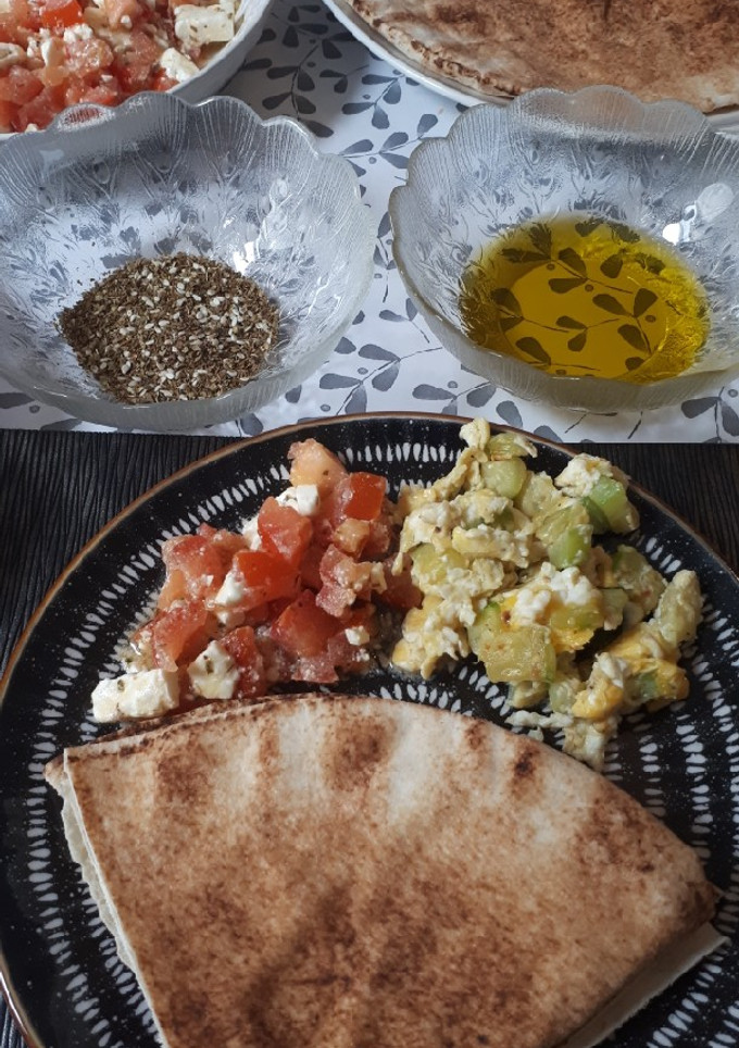 Una foto de Brunch de ensalada de tomate y queso y revuelto de calabacín