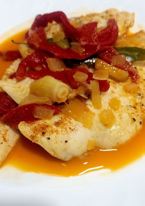 Una foto de Filetes de merluza con pimientos de piquillo y ajos confitados