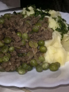 A picture of Mashed potatoes with minced meat and green peas stew.