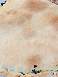 Una foto de Empanada de espinacas, piñones y pasas