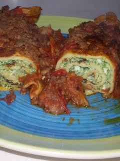 Una foto de Canelones de espinaca y ricota con salsa bolognesa achorizada