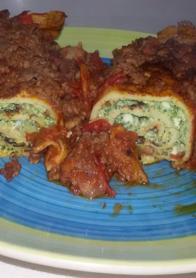 Una foto de Canelones de espinaca y ricota con salsa bolognesa achorizada