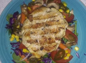Una foto de Pollo a la plancha en cama de ensalada fresca