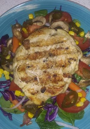 Una foto de Pollo a la plancha en cama de ensalada fresca