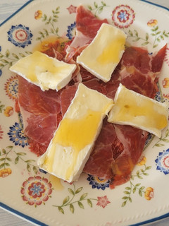 Una foto de Carpaccio de higos, un buen jamón ibérico, queso brie y miel