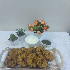 A picture of Sabudana vada donut with sweet curd and mint chutney.