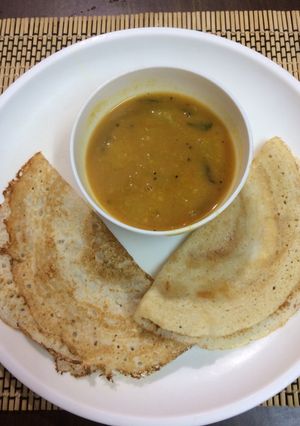 A picture of Urad dal Lapsi dosa with toor dal pumpkin sambar.