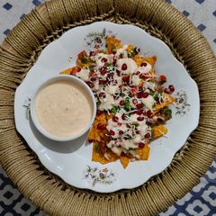 A picture of Cheesy nachos with salsa.