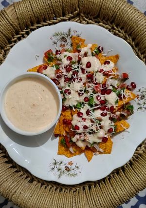 A picture of Cheesy nachos with salsa.