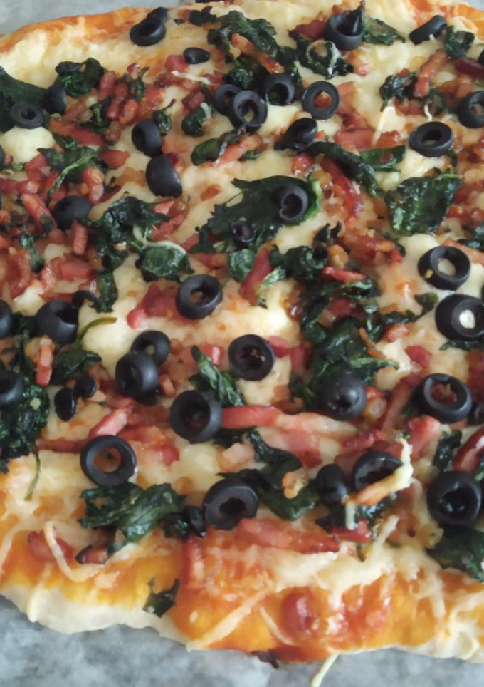 Una foto de Pizza de espinacas, cebolla, bacon y aceitunas negras