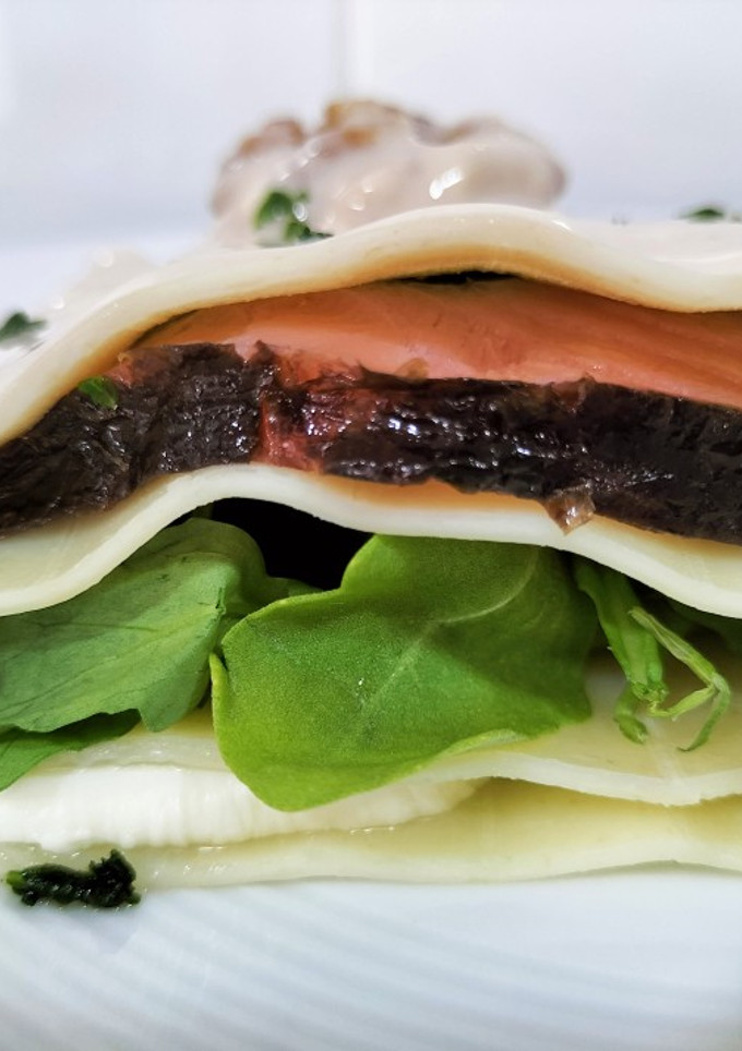 Una foto de Lasaña fría de rúcula, salmón, mozzarella y salsa de queso con nueces