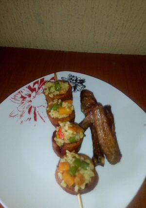 A picture of Fried rice in Skewed Plantain rings and fried Chicken.