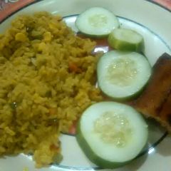 Garnished jellof rice with chicken and cucumber A picture of Garnished jellof rice with chicken and cucumber.