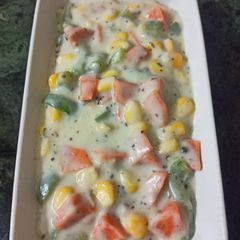 A picture of Boiled veggies in white sauce seasoned with black pepper and herbs.
