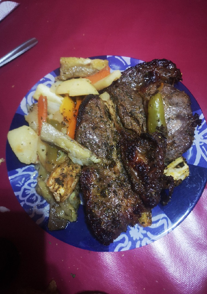 Una foto de Chuletón de ternera al horno con patatas y guarnición
