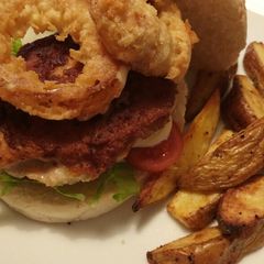 A picture of Chicken burger with beer battered onion & Cajun wedges.