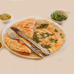 A picture of Butter dosa topped with baloon vine leaves.