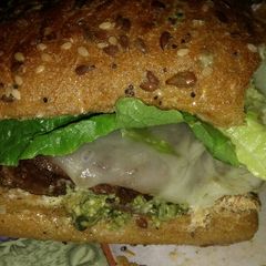 A picture of Michael's FLG (Finger Licking Good) Angus beef and basil Pesto cheeseburger with provolone and sun dried tomatoes.