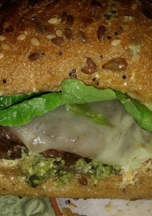 A picture of Michael's FLG (Finger Licking Good) Angus beef and basil Pesto cheeseburger with provolone and sun dried tomatoes.