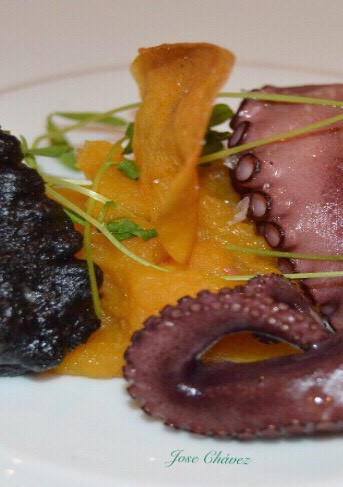 Una foto de Pulpo asado con textura de batata y cebolletas en tempura negra