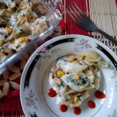 A picture of Baked shell pasta stuffed with creamy sauce.
