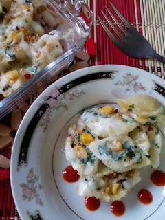 A picture of Baked shell pasta stuffed with creamy sauce.