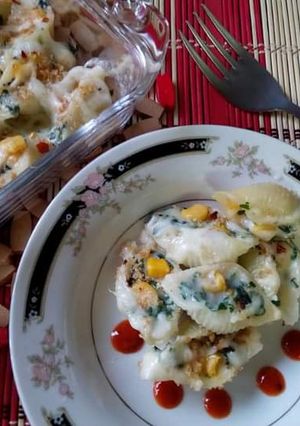 A picture of Baked shell pasta stuffed with creamy sauce.
