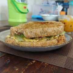 A picture of Sandwich scramble egg, salad, n bacon.