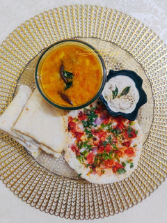 A picture of South Indian Thali-Uttapam, Neer Dosa, Sambhar, coconut chutney.